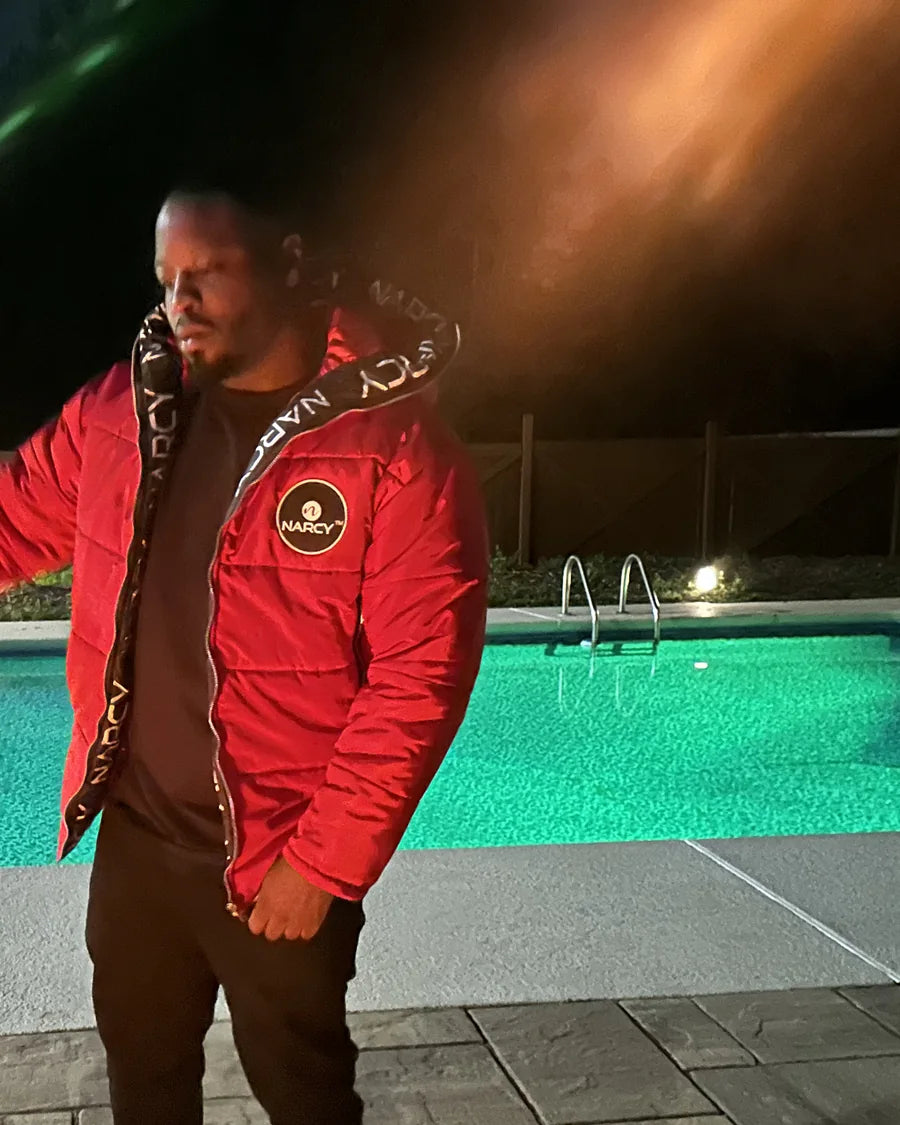 Adult man wearing red Narcy outerwear beside a pool at night